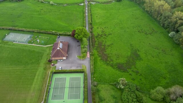 Aerial video flying over a tennis court and local sport centre