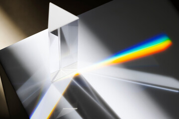 Transparent prism dispersing sunlight splitting into a spectrum on a white background