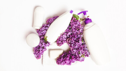 organic body care products on white background with lilac flowers. Cosmetic products, toiletries for hygiene.