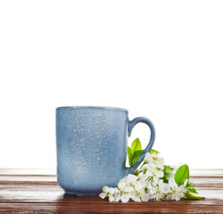 Blue ceramic cup with cherry blossoms isolated on a white background.