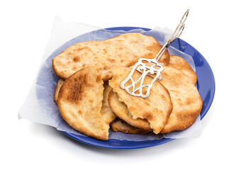 Spanish tortas de aceite on a blue plate with pastry tongs  Isolated on white background.