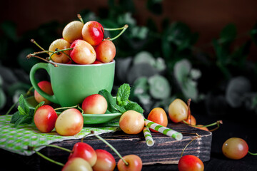 Fresh cherry in a Cup on a dark rustic wooden table. Background with space for copying. Selective focus.
