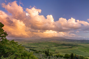 Sunset lighting up clouds over farmland near Pienza in Tuscany