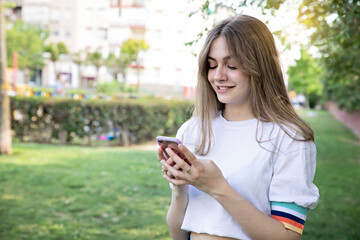 Beautiful teenager girl using smartphone outdoors