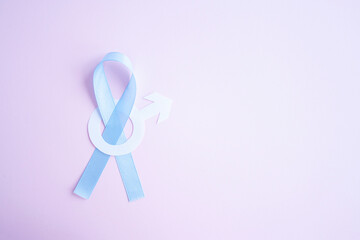 Obraz na płótnie Canvas Prostate cancer awareness blue ribbon with white paper male sign mars arrow copy space on pink background. Men healthcare concept, men carcinoma symbol.