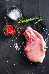 Organic chop on a bone or Pork belly fresh raw meat with spices and rosemary and red pepper on...