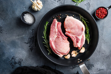 Pork steaks, fillets for grilling, baking  in frying pan black skillet with herbs, spices  top view...