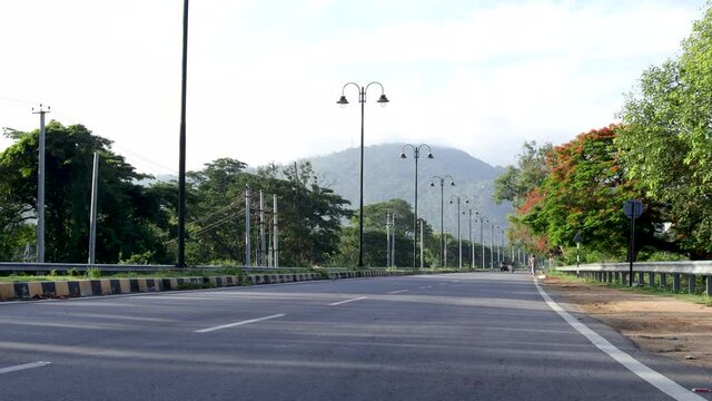 A Street view of Mysore cityscape with picturesque  highway road, street lamps and the Chamundi Hills in the far background in India.