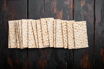 Whole grain crisp bread, on old dark  wooden table background, top view flat lay, with copy space...