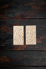 Crispbread with sunflower, chia and sesames seeds, on old dark  wooden table background, top view flat lay, with copy space for text