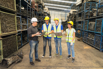 Men and women work together, use laptop. Caucasian engineer man use laptop to explain Asian engineer worker woman and men in factory-warehouse