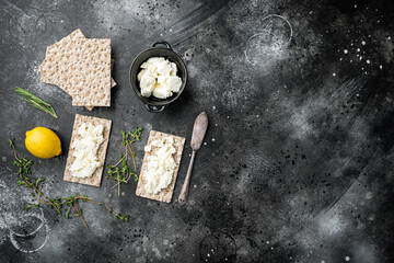 Crispbreads with feta, on black dark stone table background, top view flat lay, with copy space for...