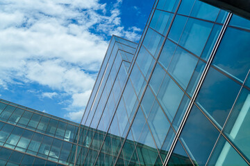 Low angle view of modern glass office building abstract background. Exterior office glass building architecture. Company glass window. Skyscraper corporate building. Financial business center tower.