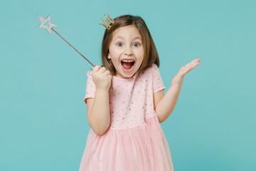 Little fun kid girl princess 5-6 years old wears pink dress crown diadem hold magic wand fairy stick isolated on pastel blue color background child studio. Mother's Day love family lifestyle concept.