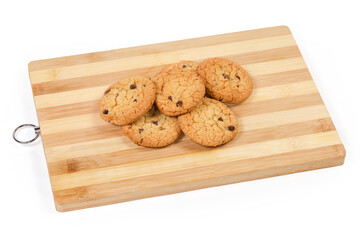 Chocolate chip cookies on wooden cutting board on white background