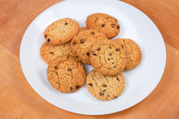 Chocolate chip cookies on dish on a wooden surface