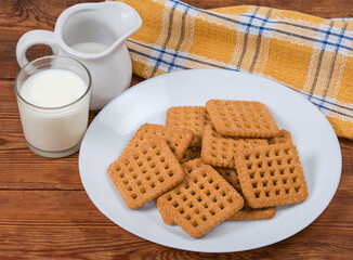Flat square sugar cookies and dairy products on rustic table