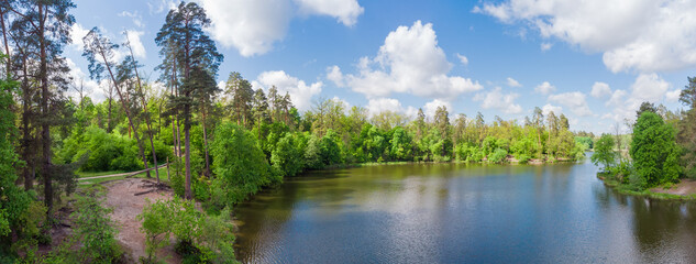 Lake with coniferous and deciduous forest on shores, panoramic view