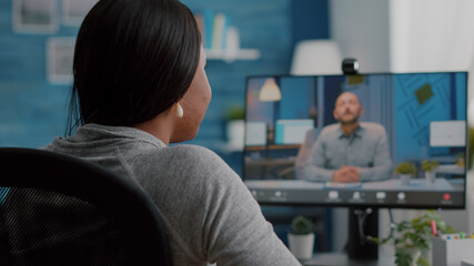 African american student discussing with college entrepreneur during online videocall telework meeting conference. Woman working remote from home having teleconference marketing university webinar