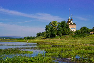 Obraz premium A crane near the Church of the Nativity of the Blessed Virgin Mary, the Church of the Nativity of the Virgin and the Ascension, built in 1895, the village of Kuznetsk, Chelyabinsk region