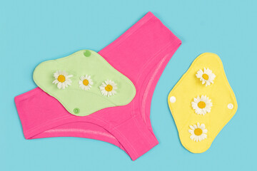 Bright panties and bamboo charcoal washable sanitary napkins with chamomile flowers on blue...