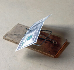 An American hundred-dollar bill in a mousetrap. A financial trap.    