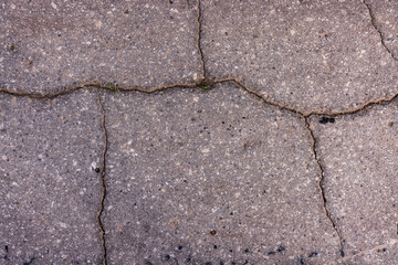 Fototapeta premium The texture of the asphalt in the cracks, hard crumbling asphalt in the village.