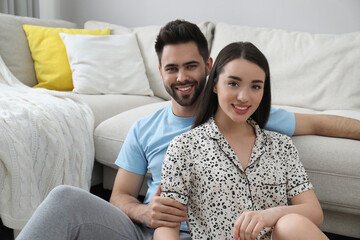 Happy young couple in pajamas at home