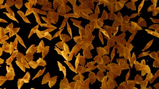 Super slow motion pasta farfalle dry. On a black background.Filmed on a high-speed camera at 1000 fps. High quality FullHD footage