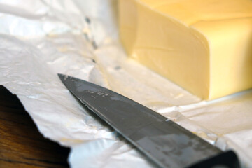 A piece of butter with a knife.