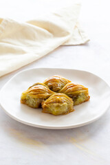 Mussels baklava Turkish pistachio baklava on a white background. Local name midye baklava