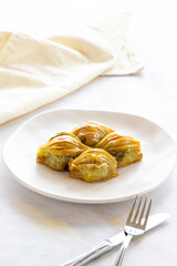 Mussels baklava Turkish pistachio baklava on a white background. Local name midye baklava
