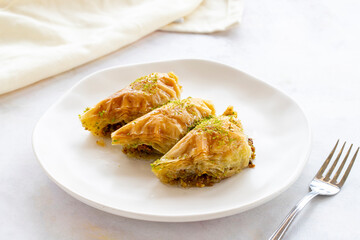 Turkish Dessert Sobiyet Baklava. Turkish pistachio baklava on a white background. Local name şöbiyet baklava