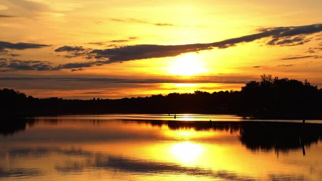 River reflections of clouds in a golden sky drifting past partial solar eclipse.