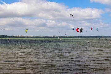 Lots of kite surfing activity at the Baltic Sea beach of Laboe in Germany on a sunny day.