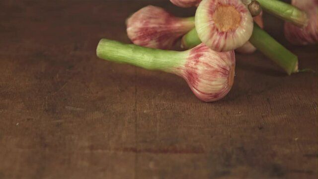 Super slow motion garlic falls on a wooden table. Filmed on a high-speed camera at 1000 fps.High quality FullHD footage