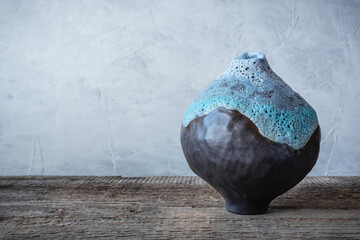 Handmade ceramics in the style of wabi sabi. Brown clay vase with an abstract blue pattern.
