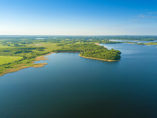 Beautiful aerial landscape on the lake with a drone. Many lake islands covered with forests, fields on a sunny day