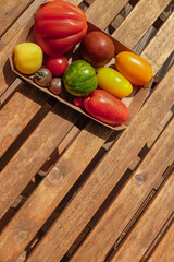 Variety of tomatoes on a wooden table with copy space