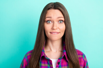 Fototapeta premium Portrait of attractive worried girl wearing checked shirt biting lip oops isolated over bright teal color background