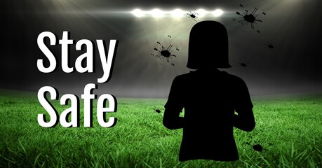 Composition of stay safe text and covid 19 cells with girl silhouette over sports stadium