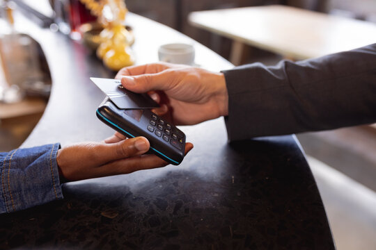 Mid section of man making a payment by credit card at a cafe