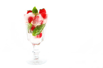 Fresh strawberries with chunks of ice in a glass . Basil leaves. Strawberry lemonade in a transparent glass. Copy of space. White background.Refreshing drink.