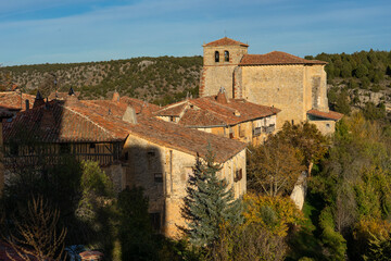 Fototapeta na wymiar Aerial view of the traditional houses of the medieval village of Calatañazor and the church in a sunny day, Soria in autumn, Castilla y Leon, Spain.