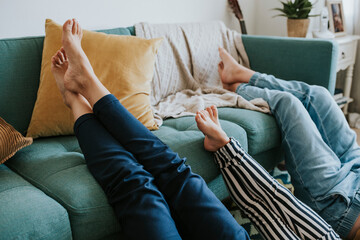 Mom and her kids putting their legs up on the couch