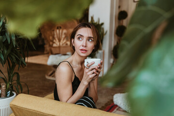 Woman having a coffee in her living room