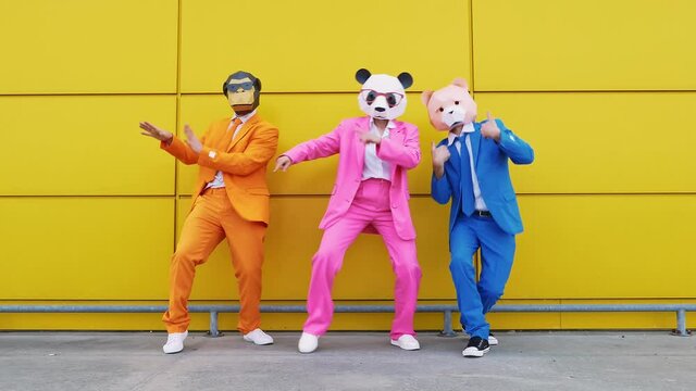 Business people in vibrant suits and animal masks dancing happily