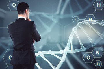 Young businessman looking at abstract glowing DNA screen. Bioengineering and science concept....