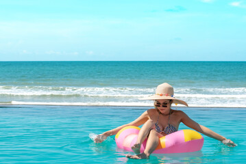 Smiling Young Woman Sitting On Pool Raft In Pool Against Sea.