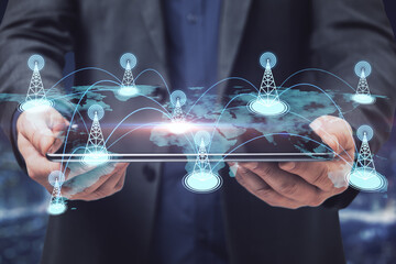 Businessman hand holding tablet with creative glowing digital map with location pins on blurry background. Double exposure.